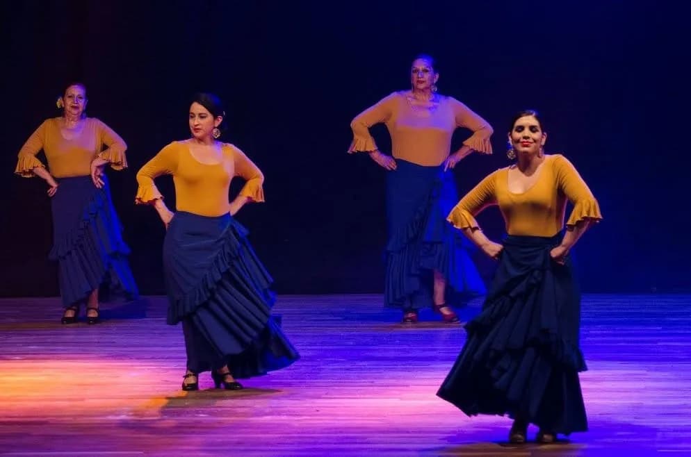 Alumnas de la Escuela de Flamenco Marcia Jara en una presentación con vestuario amarillo y azul